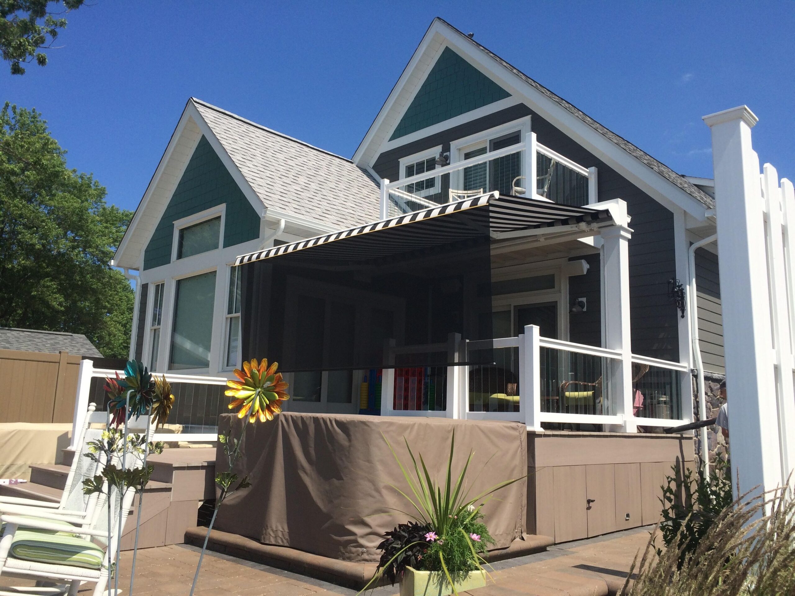 A charming house featuring a spacious deck and a protective awning